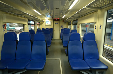 Empty 2 class compartment of wagon of commuter train, seats and doors