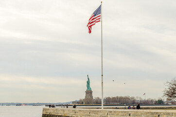 Fototapeta premium United States of America Flag and Statue of Liberty Enlightening the World. New York City, USA