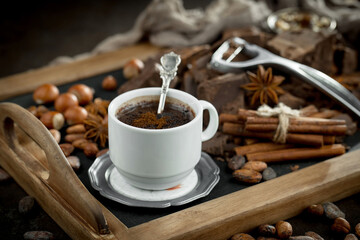 Hot chocolate on an old background in a composition with cocoa beans and nuts.