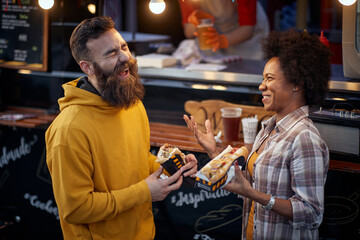 multiethnic couple laughing out loud, having a good time, talking, eating