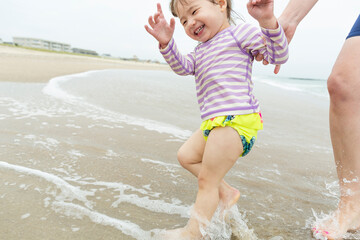 Toddler Girl Laughs and Smiles Running Through Atlantic Ocean Water