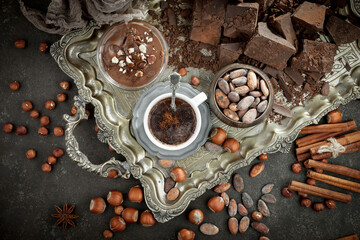 Pieces of dark chocolate and cocoa beans in composition on old background