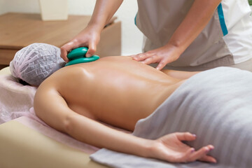 Massage therapist massaging young woman. Vacuum massage, the female body skin care.