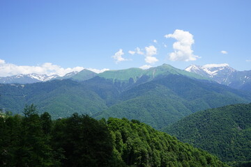 beautiful green mountains with snow on a background of clouds. Rosa Khutor . Summer