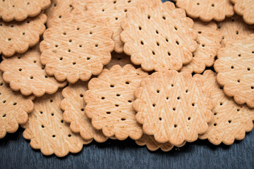 Close up of many little cookies on a black wooden table  