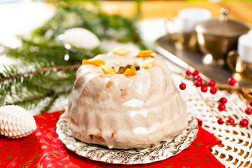 Christmas cake kuglof with white glaze topping, beautifully decorated red green nutcracker