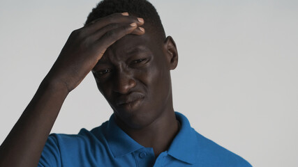 Portrait of upset African American guy feeling headache over white background