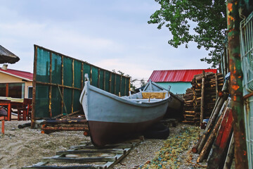 Barca, redes y otros aparejos de pesca fuera del agua en un refugio de un pescador. Barco tradicional de pesca en la playa de Olimp en Rumanía. - obrazy, fototapety, plakaty