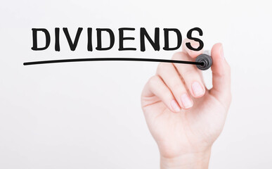 Hand writing Dividends with black marker on transparent wipe board