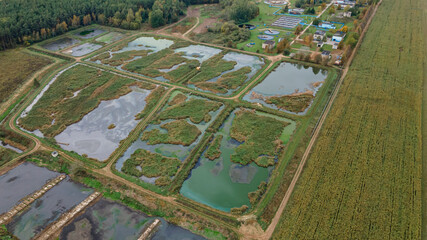 Obraz premium Sewage treatment plant. Garbage dump with treatment facilities near a small city, photo from a drone from a height. Ecological problem.