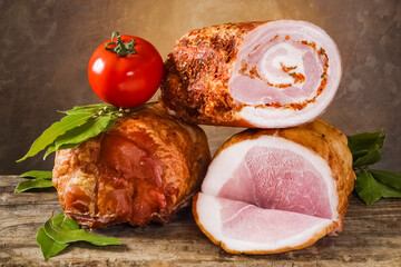 A variety of meat products including pork, beef and fresh vegetables on a old wooden table and dark painted background