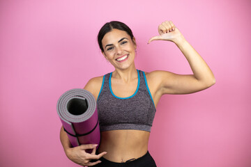 Young beautiful woman wearing sportswear over isolated pink background looking confident with smile...