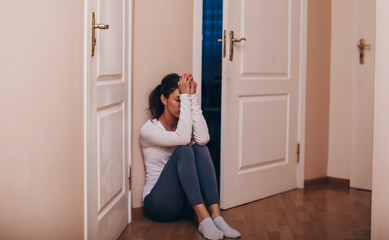 sad woman hug her knee and cry. Sad woman sitting alone in a empty room.
