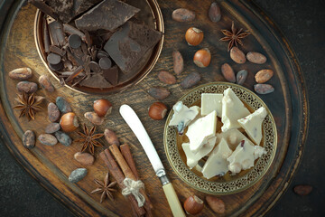Hot chocolate on an old background in a composition with cocoa beans and nuts.