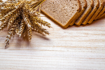 Rustic rye. Fresh loaf of rustic traditional bread with wheat grain ear or spike plant on wooden...