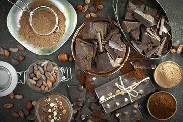 Dark chocolate in a composition with cocoa beans and nuts, on an old background.