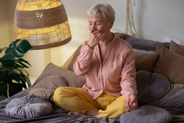 Woman practicing yoga at home, making Alternate Nostril Breathing exercise