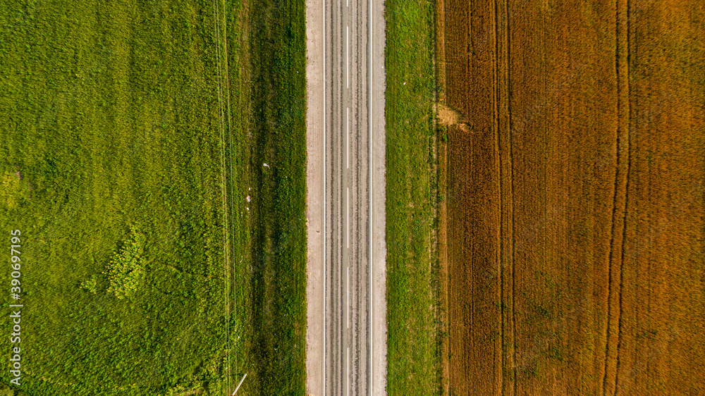 Canvas Prints Aerial shot of an empty highway on a green and brownfield