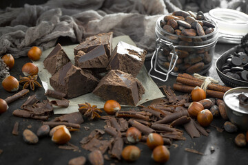 Pieces of dark chocolate and cocoa beans in composition on old background
