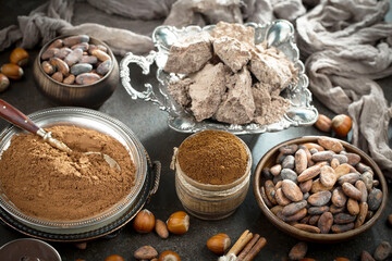 Pieces of dark chocolate and cocoa beans in composition on old background