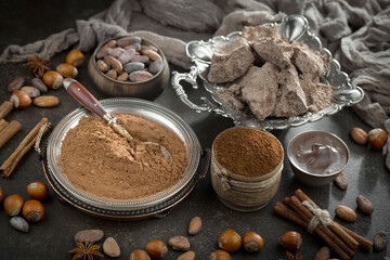 Pieces of dark chocolate and cocoa beans in composition on old background
