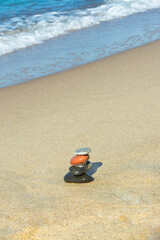 Stones in the pyramid are balanced on seashore. Harmony and meditation concept. Copy space, selective focus