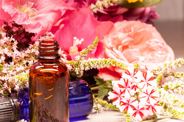 flowers and bottles of essential oils for aromatherapy