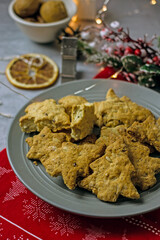 Homemade Christmas gluten-free cookies in the form of a Christmas tree and  stars on a gray plate close-up. Healthy festive diet baking concept
