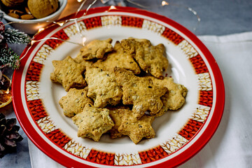 Homemade Christmas gluten-free cookies in the form of a Christmas tree and  stars on a gray plate close-up. Healthy festive diet baking concept