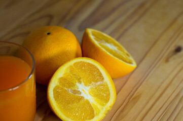 Orange juice glass with sliced orange on wooden table