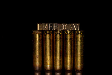 Freedom text message on 50 cal bullet casings against black background