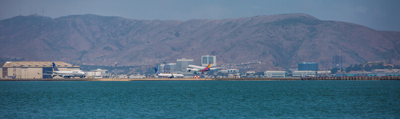 Fototapeta na wymiar San Francisco International Airport - with landing and taxiing airplanes - panoramic view
