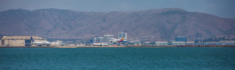 Selbstklebende Fototapeten San Francisco International Airport - with landing and taxiing airplanes - panoramic view © Mario Hagen
