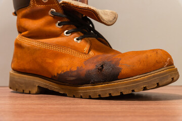 A ruined shoe. Cracks and stains on the surface of the shoe.