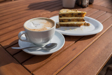 carrots and pumpkin cake with coffee cream in a cut on the plate.Delicious sliced carrot cake.Slice of cake on a white saucer, decorated with walnuts,