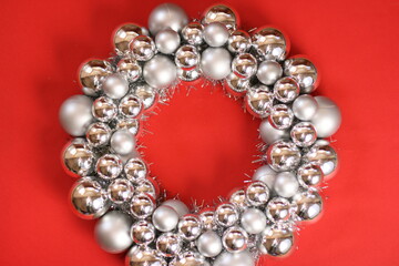 Wreath on red background. New Year's wreath. Christmas decorative toys. Christmas, winter, new year concept. Flat lay, top view, copy space.