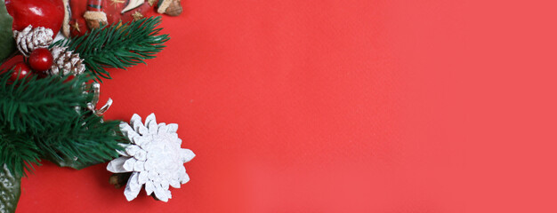 Christmas and New Year's Day decoration, fir cones, branches on red background. Flat lay. New Year photo with copy space. Banner size.