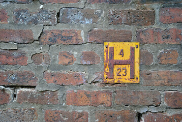 Old Brick Wall with Close Up of Yellow Metal Fire Hydrant Sign