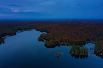 Aerial View on the lake in the forest at dusk 