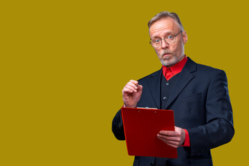 Manager in suit and red shirt taking notes. Man holding folder with documents over yellow background. Cropped photo.