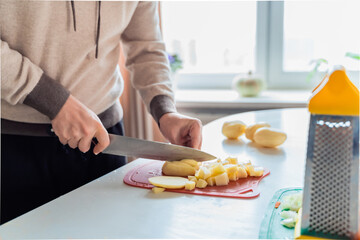Cooking man, father, cooker. Preparation of soup, lunch, dinner in kitchen. Cutting vegetables,...