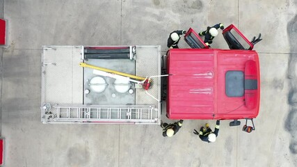 Four  fire fighters get in fire truck for emergency rescue operation.  Aerial view.