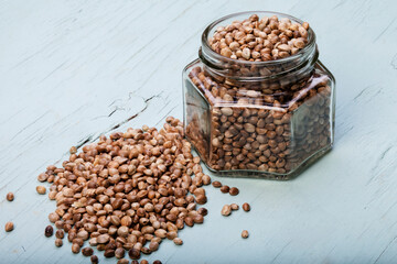 hemp leaves on wooden background, seeds, cannabis oil extracts in jars
