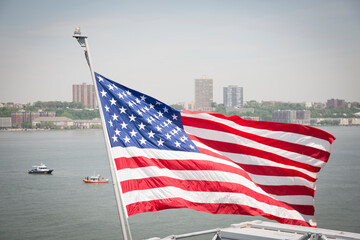 The red white and blue American Flag, the nations ensign, flying over the Hudson River.