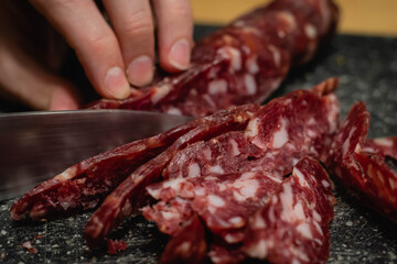 tipico y tradicional salame argentino con grasa y especies cortado fino con cuchillo sobre base...