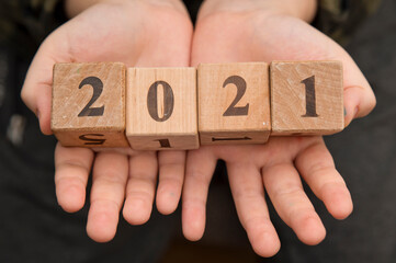 Happy new year 2021 Christmas and New Year background. Symbol from number. Wooden cubes on hands.