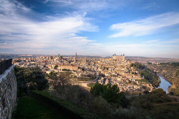 Fototapeta na wymiar Panoramic view of the old town of the monumental city of Toledo from a balcony with a blue sky with clouds, Spain