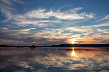 Fototapeta na wymiar Sunset over the lake and beautiful clouds