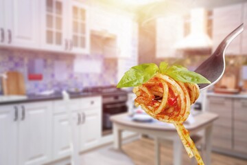 Metal fork with delicious spaghetti and sauce