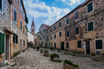 Street with typical stone houses in Postira old town, Brac island, Croatia. August 2020